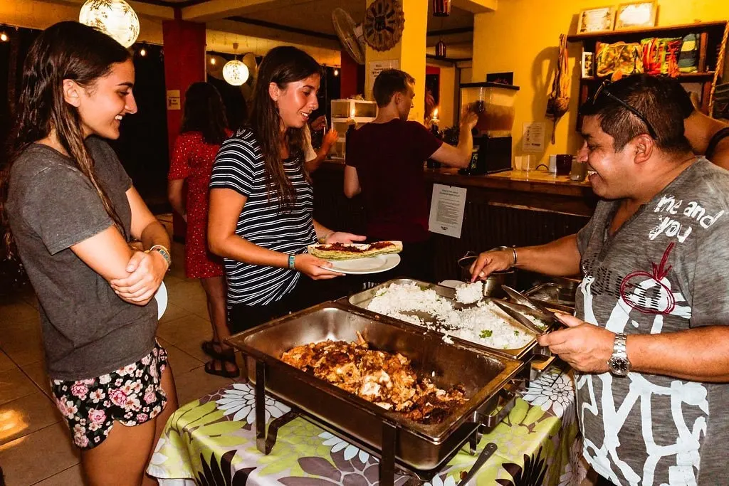 Huéspedes y anfitriones sirviendo la cena en el buffet