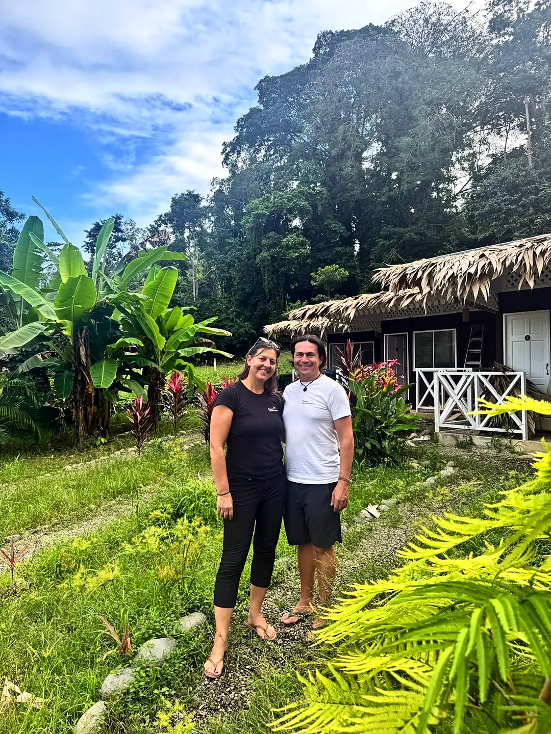Beate y Federico, fundadores de Planet Conservation, frente a una cabaña con techo de palma