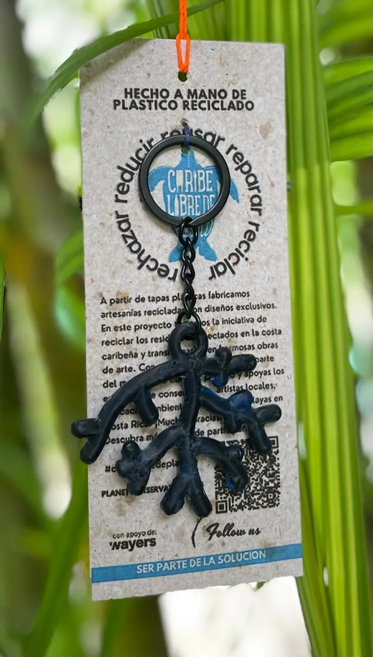 Llavero negro con forma de coral sobre su tarjeta