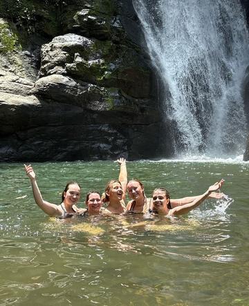 Grupo bañándose bajo una cascada